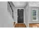 Foyer with hardwood floors, a black front door with decorative glass, and stairs with white railings at 1344 Baez St, Raleigh, NC 27608