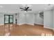 Open-concept living room with hardwood floors, recessed lights, ceiling fan, and doors to the outside at 1344 Baez St, Raleigh, NC 27608
