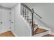 Traditional staircase with hardwood steps, white risers, black banister, and a white door at 1344 Baez St, Raleigh, NC 27608