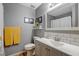 Bathroom with gray vanity, white sink, tile backsplash and decor at 135 Crooked Creek Run, Louisburg, NC 27549