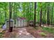 View of two sheds, one of which has a shelter attached, nestled among mature trees at 135 Crooked Creek Run, Louisburg, NC 27549