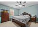 Comfortable bedroom with blue walls, ceiling fan and a large window allowing natural light at 138 Tramway Cir, Angier, NC 27501