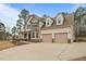 Beautiful two-story home with a two-car garage, covered porch, and long driveway on a sunny day at 138 Tramway Cir, Angier, NC 27501