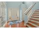 Light-filled foyer showcasing hardwood floors, a staircase with wood railings, and an inviting front door at 138 Tramway Cir, Angier, NC 27501