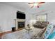 Inviting living room with a cozy fireplace, plush leather seating, and a ceiling fan for comfort at 138 Tramway Cir, Angier, NC 27501