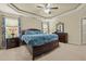 Spacious main bedroom featuring a trey ceiling, a plush bed, and matching dark wood furniture at 138 Tramway Cir, Angier, NC 27501