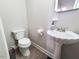 Simple and clean half-bathroom with pedestal sink and toilet providing a functional and space-saving design at 141 Jones Franklin Rd # E, Raleigh, NC 27606