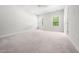 Spacious bedroom with neutral carpet, two windows, and ample natural light at 1437 Newpoint Dr, Durham, NC 27713