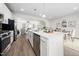Open-concept kitchen featuring a quartz island, stainless steel appliances, and views into the living and dining areas at 1437 Newpoint Dr, Durham, NC 27713