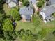 Aerial view of a beautiful backyard with a stone patio, lush greenery, and a charming playset area at 1612 Rainesview Ln, Apex, NC 27502