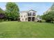 Expansive backyard showcasing lush greenery, a stone patio, and home exterior at 1612 Rainesview Ln, Apex, NC 27502