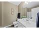 Bright bathroom features a single sink vanity, framed mirror, and shower with tile surround at 1612 Rainesview Ln, Apex, NC 27502