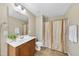 Well-lit bathroom with a wood vanity, tile floors, and a shower with neutral curtain at 1612 Rainesview Ln, Apex, NC 27502