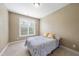 Simple bedroom with neutral colors, a comfortable bed, and natural light from a large window at 1612 Rainesview Ln, Apex, NC 27502