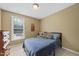 Bedroom features neutral walls, a bed with a blue blanket, and a dresser at 1612 Rainesview Ln, Apex, NC 27502