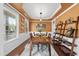 Bright dining room with natural light, tray ceiling, shelving and wood table set for a meal at 1612 Rainesview Ln, Apex, NC 27502
