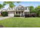 Charming two-story home featuring a landscaped front yard and a welcoming front porch with stone and siding accents at 1612 Rainesview Ln, Apex, NC 27502