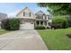 Charming two-story home featuring a stone-accented facade, a covered front porch, and a well-manicured lawn at 1612 Rainesview Ln, Apex, NC 27502