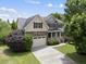 Stately two-story home with stone accents, an attached garage, and a beautifully landscaped front yard at 1612 Rainesview Ln, Apex, NC 27502