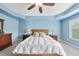 Lovely main bedroom featuring a tray ceiling, a bright blue accent wall, and large windows at 1612 Rainesview Ln, Apex, NC 27502