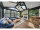 Bright sunroom with vaulted ceilings, skylights, a stone fireplace, and floor to ceiling windows offering views of the backyard at 1612 Rainesview Ln, Apex, NC 27502