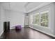 Relaxing bedroom with hardwood floors, large windows, and purple accent chair at 1637 Dodford Ct, Wake Forest, NC 27587