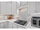Close-up of gas stovetop with herringbone backsplash and white marble countertops at 1637 Dodford Ct, Wake Forest, NC 27587