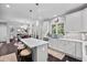 Open-concept kitchen with an island, white cabinets, and a seamless view into the dining and living area at 1637 Dodford Ct, Wake Forest, NC 27587