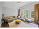 Inviting living room with ample seating, large windows, and stylish yellow accents at 1637 Dodford Ct, Wake Forest, NC 27587