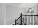 Open staircase featuring decorative iron railings, dark wood steps, and a modern chandelier at 1637 Dodford Ct, Wake Forest, NC 27587