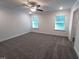 A view of a carpeted bedroom featuring large windows, ceiling fan, and ensuite at 179 New Twin Branch Ct, Smithfield, NC 27577