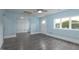 Spacious room with gray wood-look flooring, light blue walls, and a bright window at 1917 Tucker St, Burlington, NC 27215