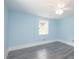 Bright bedroom featuring gray laminate flooring, a ceiling fan, and light blue walls at 1917 Tucker St, Burlington, NC 27215
