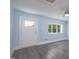 Spacious bedroom with gray wood-look flooring, light blue walls, interior door, and a bright window at 1917 Tucker St, Burlington, NC 27215