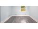 Spacious bedroom featuring gray wood-look flooring, light blue walls, and a bright window at 1917 Tucker St, Burlington, NC 27215