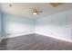 Spacious room with gray wood-look flooring, light blue walls, and a ceiling fan at 1917 Tucker St, Burlington, NC 27215