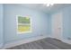 A light blue bedroom features a window and a white interior door at 1917 Tucker St, Burlington, NC 27215