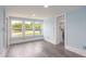 Bright living room with gray laminate flooring, large windows, and light blue walls at 1917 Tucker St, Burlington, NC 27215