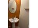 Small bathroom with a unique oval mirror and a white pedestal sink at 1937 Crag Burn Ln, Raleigh, NC 27604