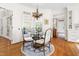 Bright dining area featuring a glass table, four upholstered chairs, and a chandelier at 20007 Bragg, Chapel Hill, NC 27517
