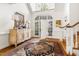 Bright foyer showcasing a decorative cabinet, rug, and staircase leading to upper level at 20007 Bragg, Chapel Hill, NC 27517