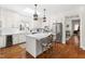 Bright kitchen featuring an island with marble countertop, stainless steel appliances, and wood floors at 20007 Bragg, Chapel Hill, NC 27517