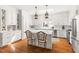 Bright kitchen showcasing white cabinetry, a large island, hardwood floors and modern appliances at 20007 Bragg, Chapel Hill, NC 27517