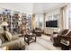 Cozy living room with built-in bookshelves, patterned armchairs, and a large window at 20007 Bragg, Chapel Hill, NC 27517