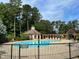 Community pool with gazebo, lounge chairs, fence, and treeline in the background at 20007 Bragg, Chapel Hill, NC 27517