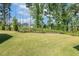 Lush backyard featuring a manicured lawn and mature trees, creating a serene outdoor space at 208 Dry Canyon Dr, Wendell, NC 27591
