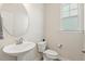 Half bathroom features pedestal sink, modern fixtures, and window at 208 Dry Canyon Dr, Wendell, NC 27591
