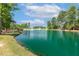 Picturesque community pond with a fountain and walking bridge surrounded by mature trees and greenery at 208 Dry Canyon Dr, Wendell, NC 27591