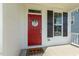 Inviting front porch featuring a vibrant red door with a charming wreath and a cozy welcome mat at 208 Dry Canyon Dr, Wendell, NC 27591