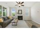 Bright living room with a fireplace, ceiling fan, modern floors, and large windows at 208 Dry Canyon Dr, Wendell, NC 27591